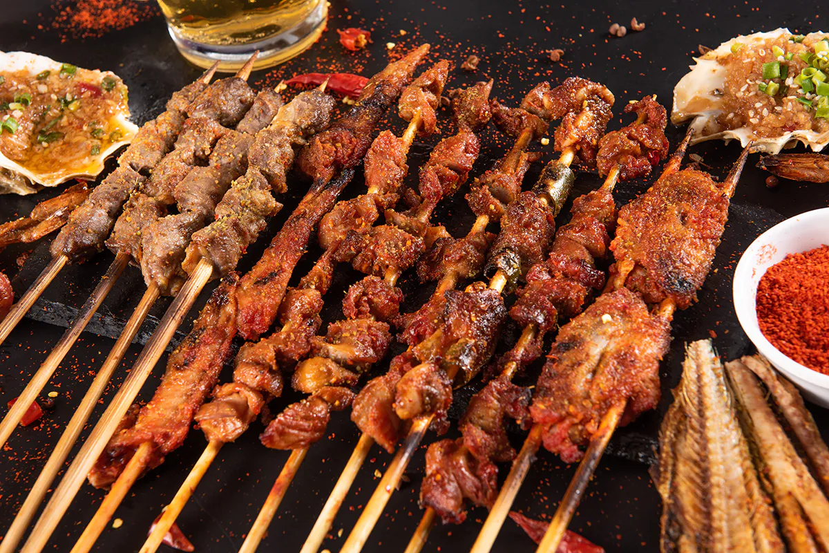 Assorted spicy meat skewers and grilled oysters at Aquaman BBQ, a Barbecue Restaurant in Queens