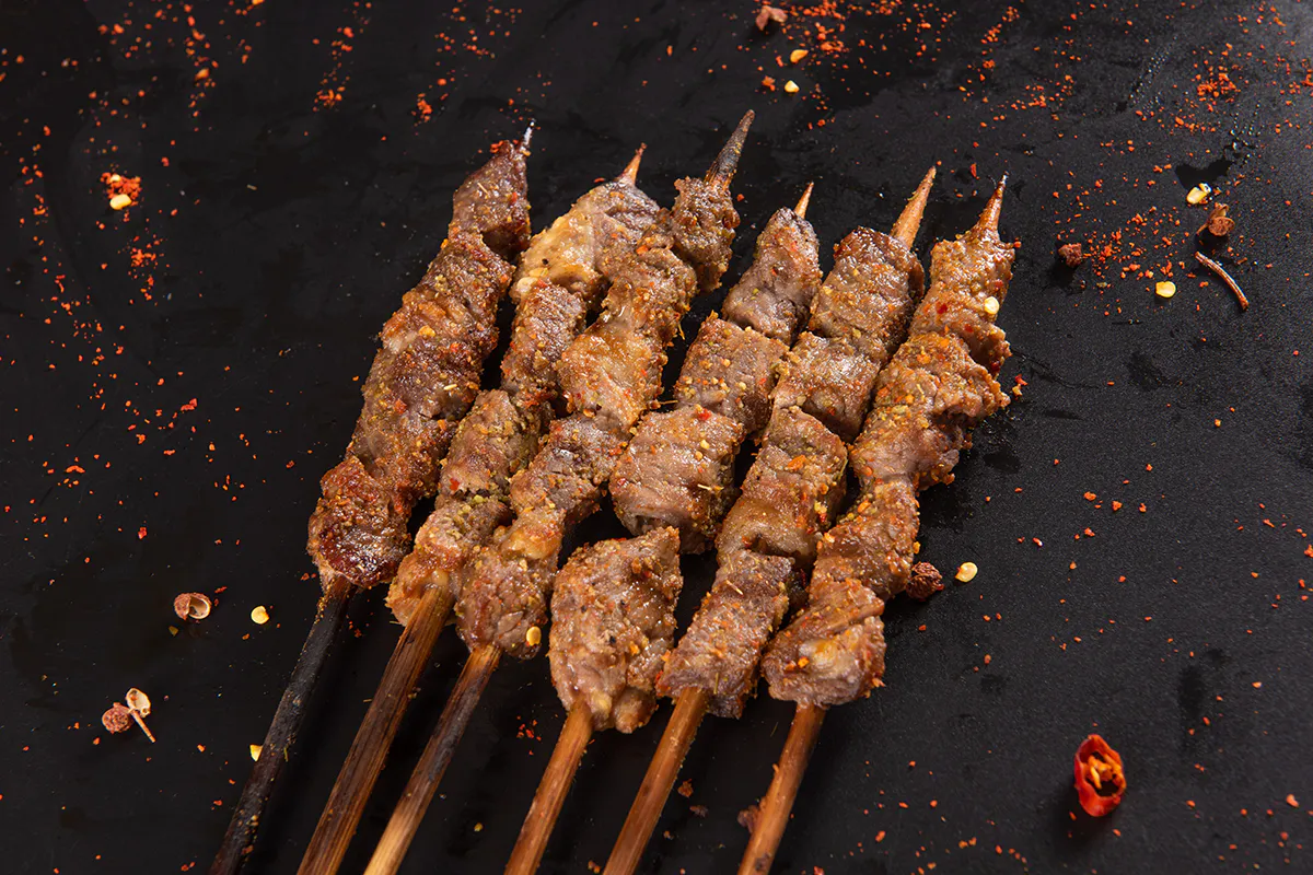 Grilled beef skewers seasoned with chili and spices at Aquaman BBQ, a Barbecue Restaurant in Queens